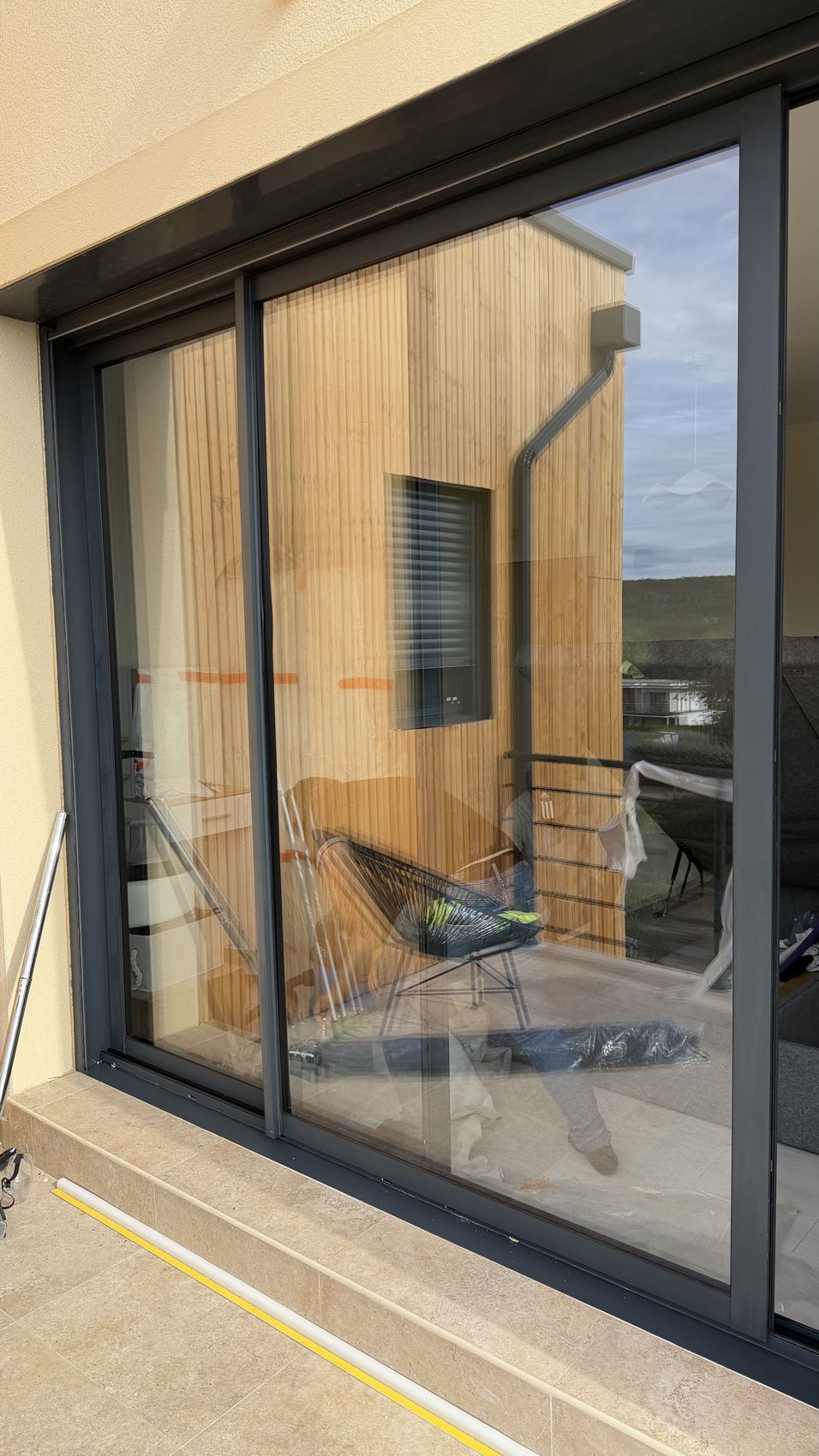 Baie vitrée coulissante propre, la façade en bois s’y reflète