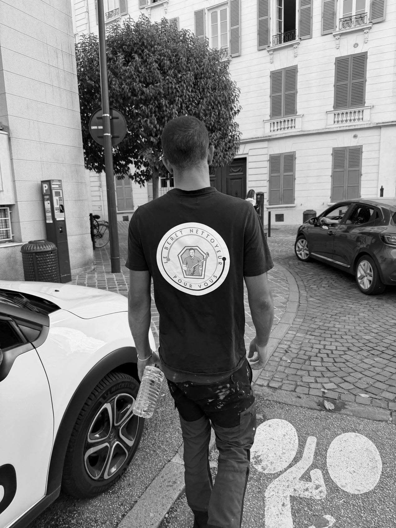 Lucas de dos dans une rue de Versailles, en tee-shirt Le Béret Nettoyeur