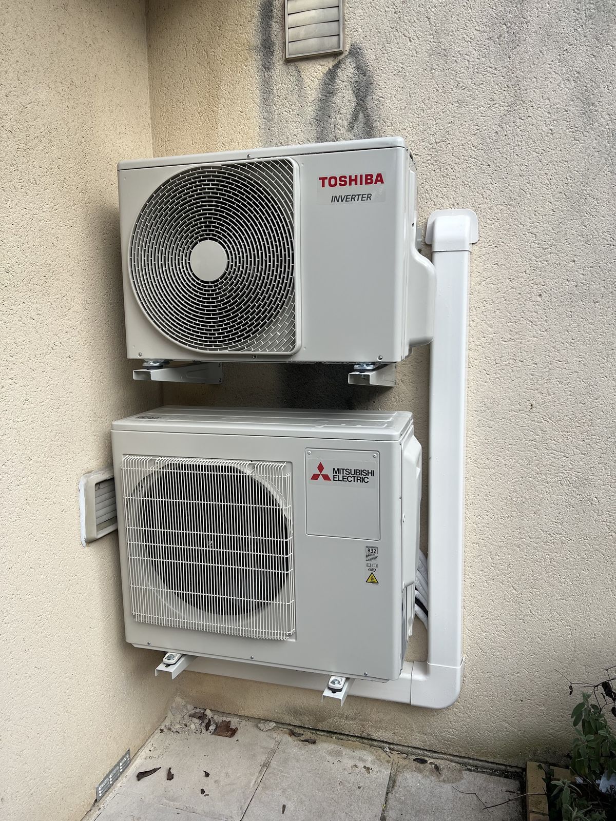 Deux groupes extérieurs, Toshiba et Mitsubishi Electric, fixés l’un au-dessus de l’autre en façade